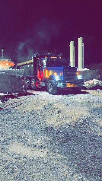 Dump truck staged on a pad at night