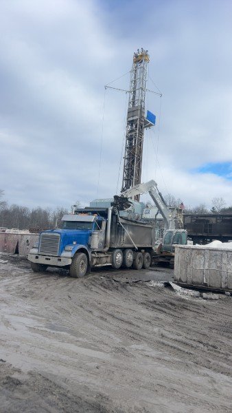 Dump truck working a winter drilling pad